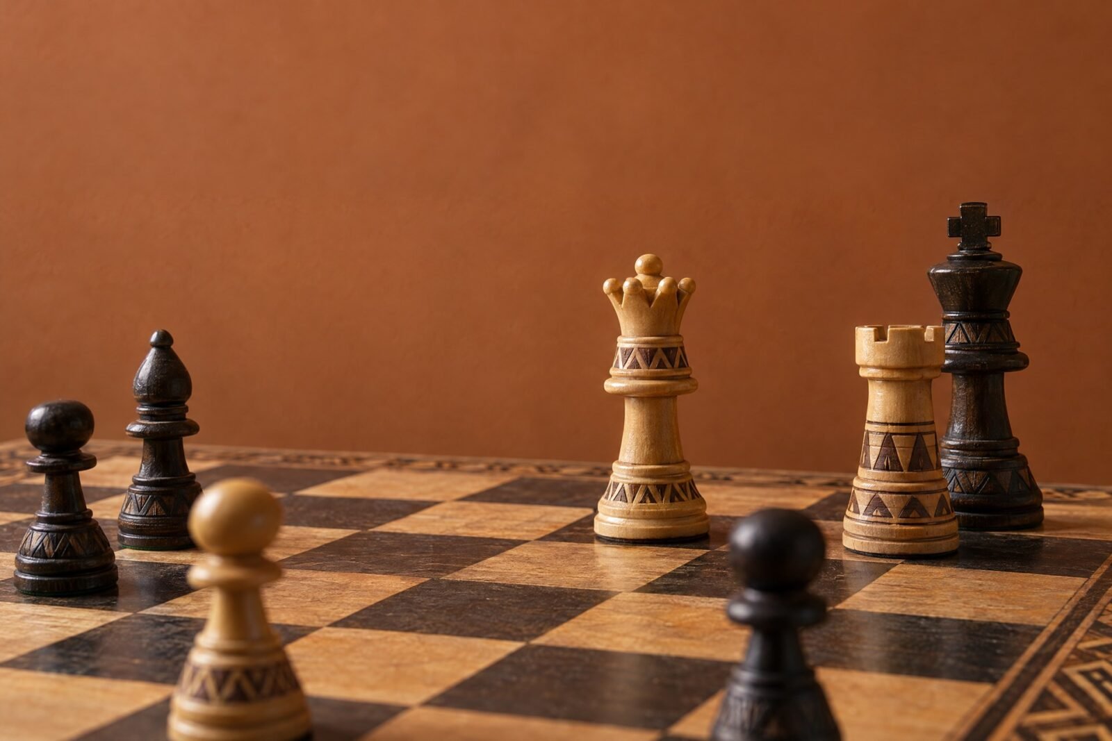 A documentary-style chess photograph in warm natural light, showing an African-designed wooden chessboard with a white rook advanced deep into a dark.